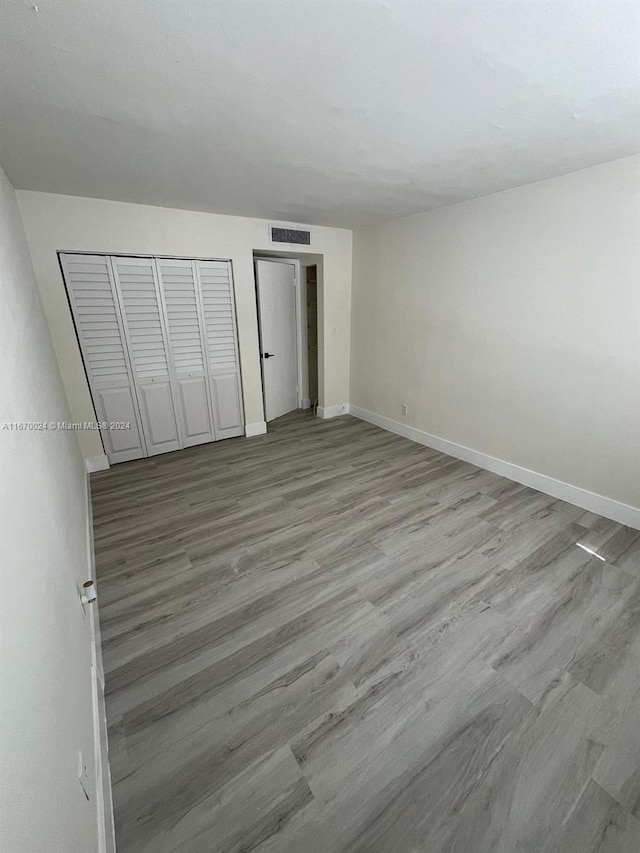 unfurnished bedroom featuring light wood-type flooring and a closet