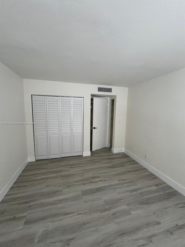 unfurnished bedroom with light wood-type flooring and a closet