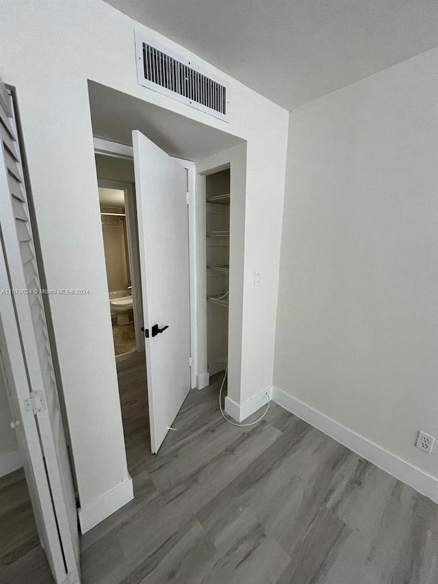 unfurnished bedroom with wood-type flooring and a closet