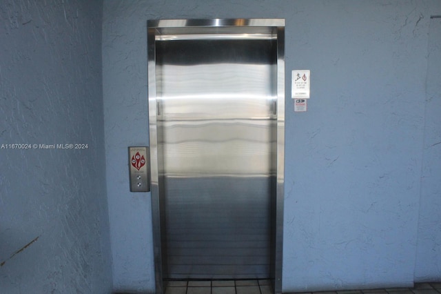 interior details featuring elevator and tile patterned floors