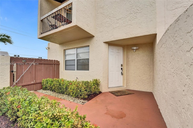 3660 SW 59th Ave Unit 1, Davie, FL 33314 - doorway to property with a balcony, stucco siding, and fence