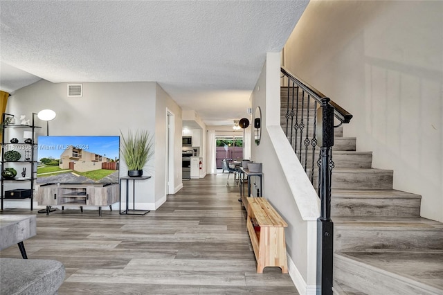 3660 SW 59th Ave Unit 1, Davie, FL 33314 - staircase featuring a textured ceiling, wood finished floors, visible vents, and baseboards