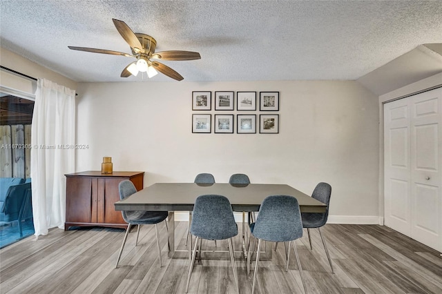 dining area with a textured ceiling, hardwood / wood-style flooring, and ceiling fan