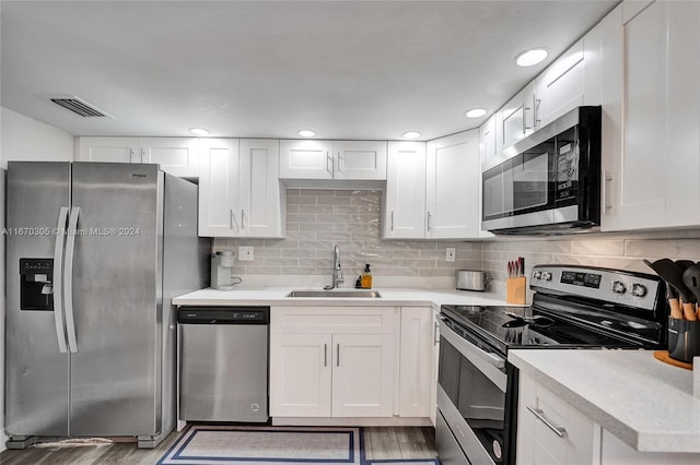 3660 SW 59th Ave Unit 1, Davie, FL 33314 - kitchen featuring wood finished floors, a sink, white cabinets, appliances with stainless steel finishes, and visible vents
