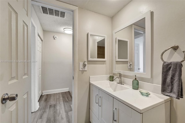 bathroom featuring a textured ceiling, vanity, and hardwood / wood-style floors