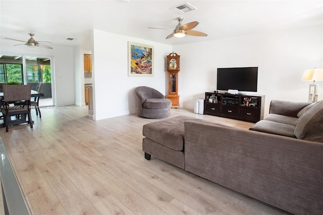 living room with ceiling fan and light hardwood / wood-style flooring