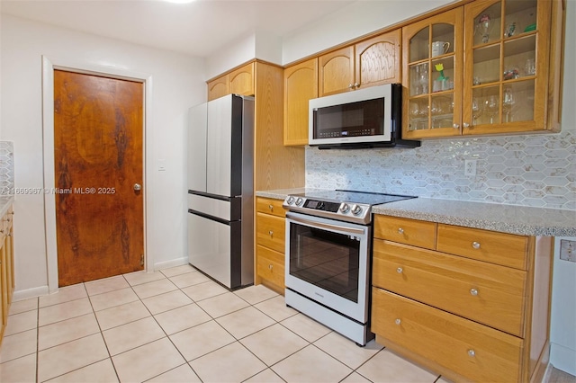 kitchen featuring tasteful backsplash, stainless steel electric stove, refrigerator, and light tile patterned floors