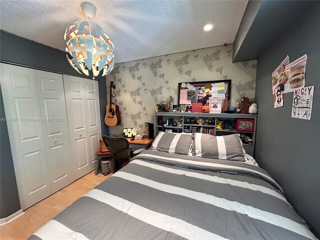 bedroom featuring hardwood / wood-style floors, a textured ceiling, and a closet