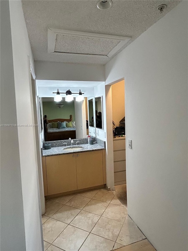 bathroom with tile patterned floors, vanity, and a textured ceiling