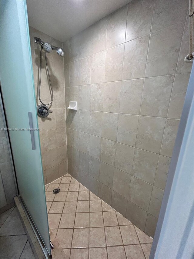 bathroom with tile patterned floors and a shower with shower door