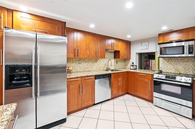 kitchen featuring light stone counters, light tile patterned floors, backsplash, sink, and stainless steel appliances