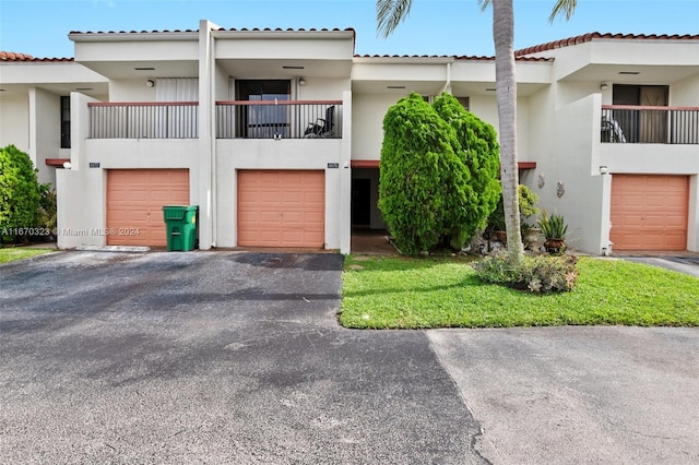 view of front of home featuring a garage and a balcony