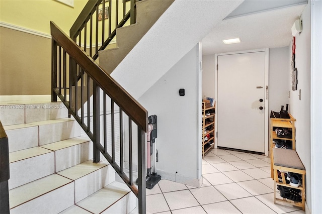 tiled entryway featuring a textured ceiling