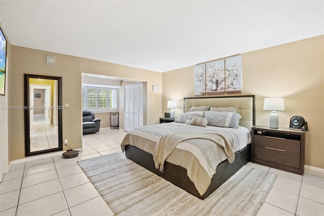 bedroom with a textured ceiling and light tile patterned flooring