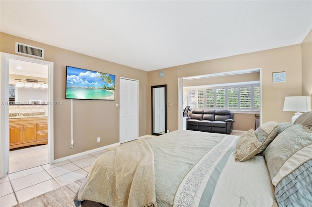 bedroom with connected bathroom and light tile patterned floors