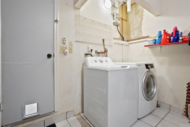 laundry area with light tile patterned flooring and washer and clothes dryer