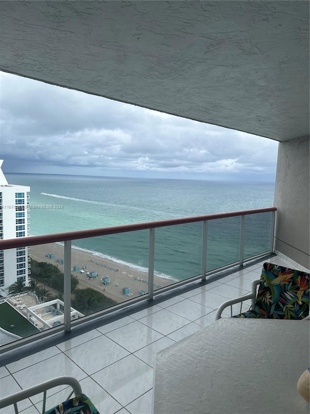 balcony featuring a water view and a beach view