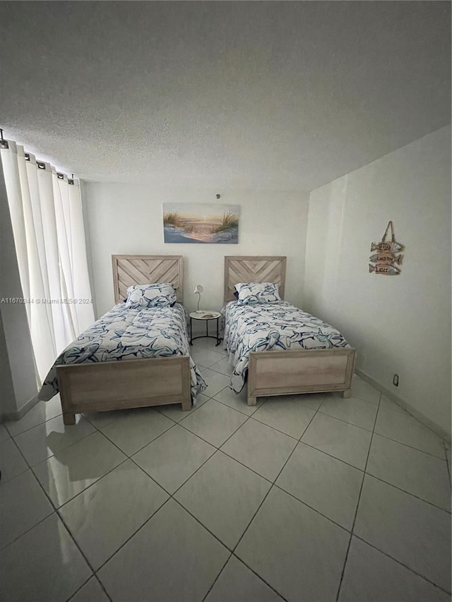 tiled bedroom with a textured ceiling