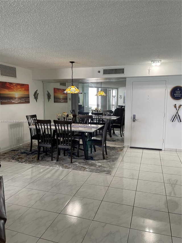 dining area featuring a textured ceiling and tile patterned flooring