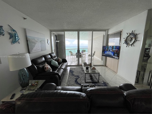 tiled living room with a textured ceiling and floor to ceiling windows