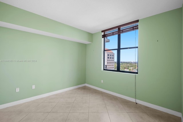 spare room with a textured ceiling and light tile patterned floors