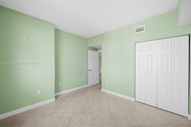 unfurnished bedroom featuring a closet and light tile patterned floors