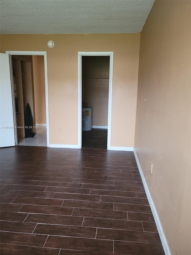 empty room with a textured ceiling and dark hardwood / wood-style flooring