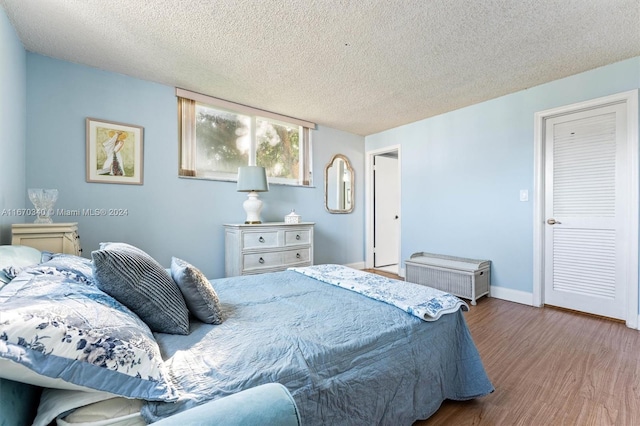 bedroom featuring a textured ceiling and hardwood / wood-style floors