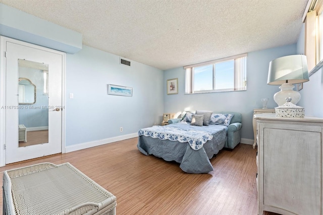 bedroom with a textured ceiling and hardwood / wood-style floors