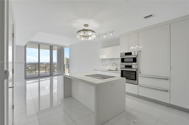 851 NE 1st Ave Unit 2200, Miami, FL 33132 - kitchen featuring floor to ceiling windows, a sink, modern cabinets, a chandelier, and white cabinetry