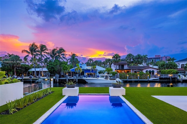 pool at dusk with a lawn and a water view