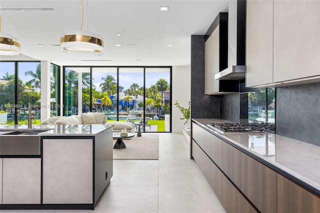 kitchen featuring stainless steel gas stovetop, plenty of natural light, decorative backsplash, and floor to ceiling windows