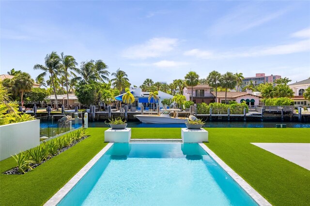 view of pool with a lawn and a water view