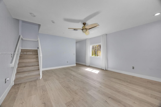 empty room with ceiling fan and light hardwood / wood-style flooring