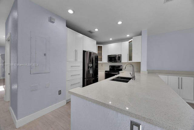 kitchen with light wood-type flooring, sink, white cabinetry, kitchen peninsula, and appliances with stainless steel finishes