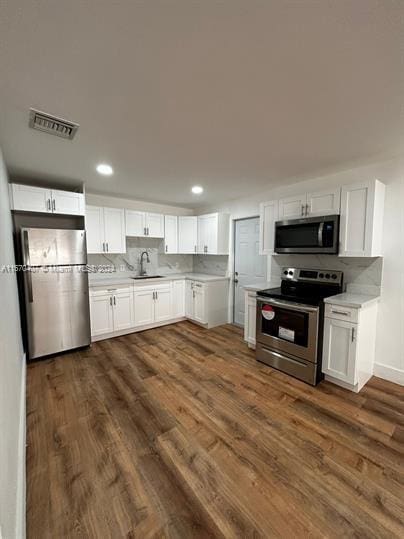 kitchen featuring white cabinetry, appliances with stainless steel finishes, sink, and dark hardwood / wood-style flooring