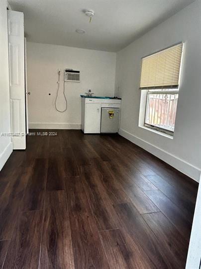 interior space featuring an AC wall unit and dark hardwood / wood-style flooring