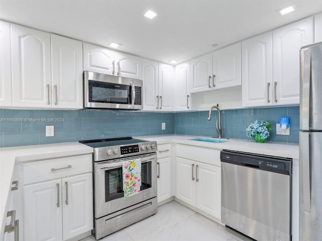 kitchen featuring backsplash, white cabinetry, sink, and stainless steel appliances