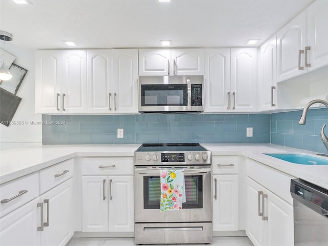 kitchen featuring appliances with stainless steel finishes, backsplash, and white cabinetry