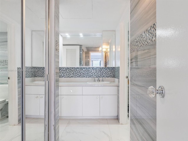 bathroom featuring tasteful backsplash, vanity, and toilet