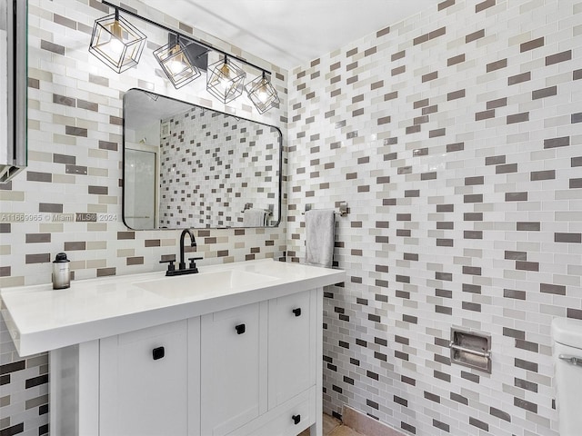 bathroom featuring tile walls, decorative backsplash, vanity, and toilet