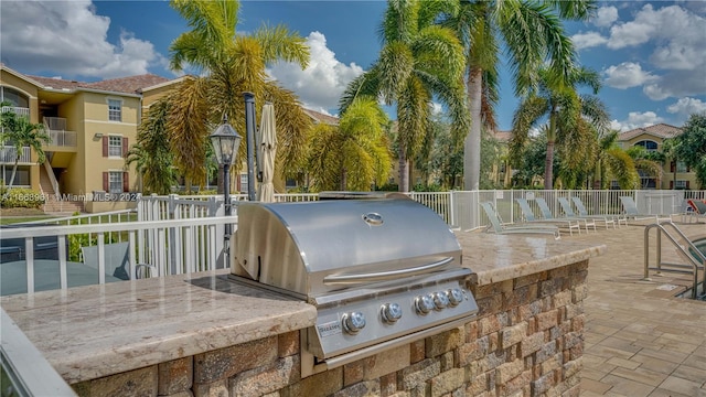 view of patio with a balcony, an outdoor kitchen, and a grill