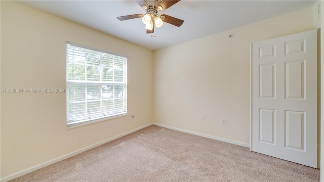 carpeted spare room with ceiling fan