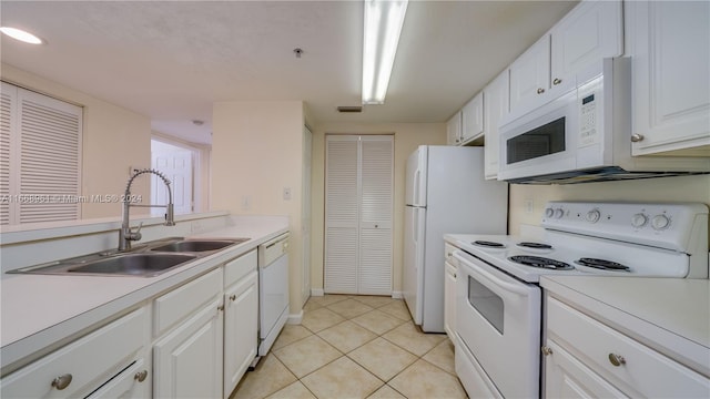 kitchen with white cabinets, white appliances, light tile patterned floors, and sink