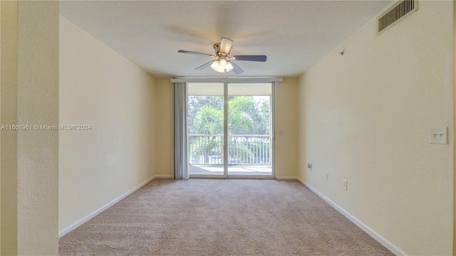 carpeted spare room featuring ceiling fan