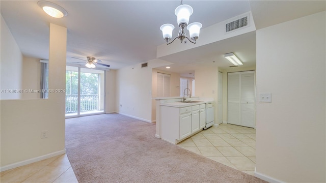 kitchen featuring white cabinets, light tile patterned flooring, decorative light fixtures, and white dishwasher