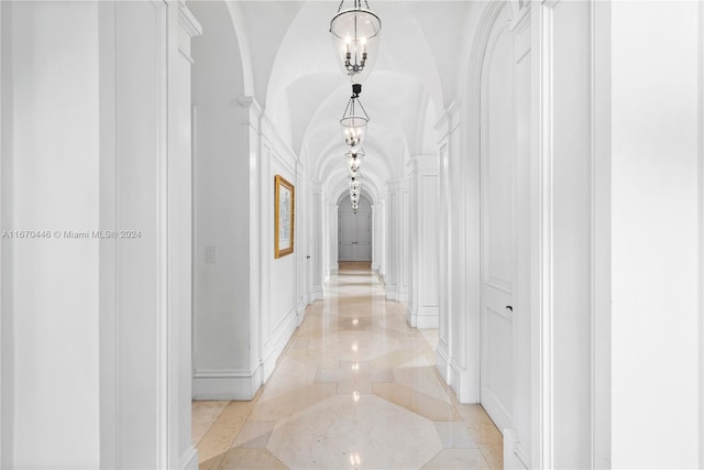 hall featuring a chandelier and vaulted ceiling