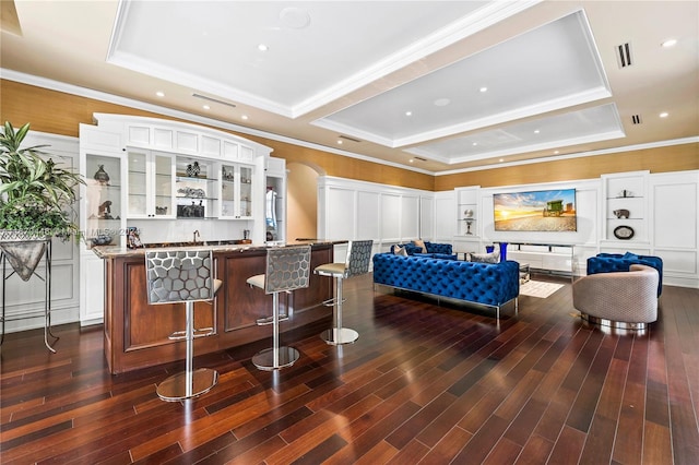 interior space featuring a raised ceiling, dark wood-type flooring, and white cabinetry