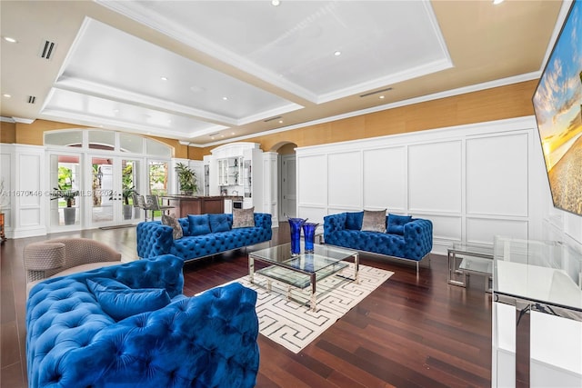 living room with ornamental molding, a tray ceiling, dark hardwood / wood-style floors, and french doors