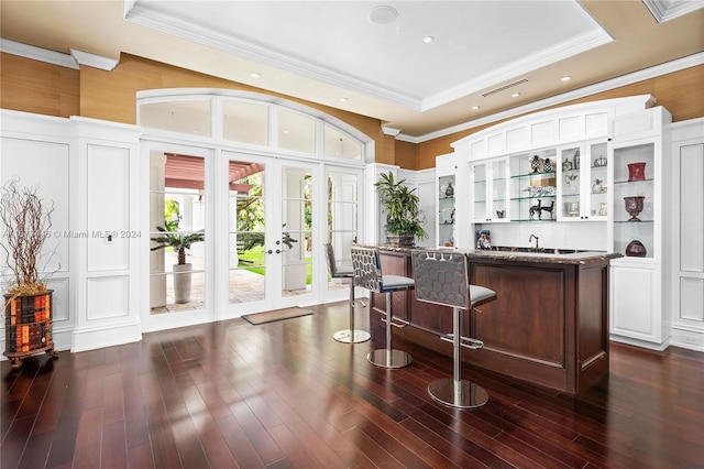 bar featuring dark hardwood / wood-style floors, white cabinets, a raised ceiling, ornamental molding, and french doors